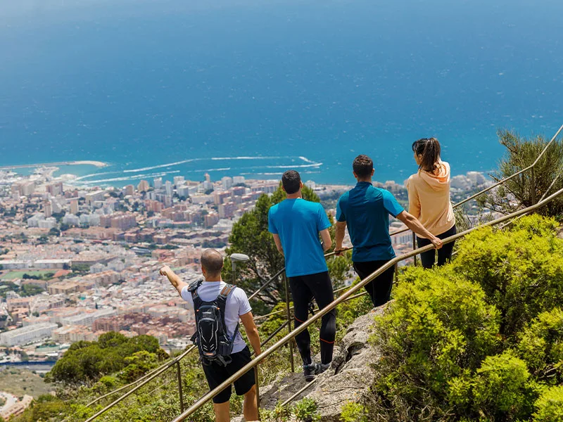 Hikers descending Monte Calamorro above the coast