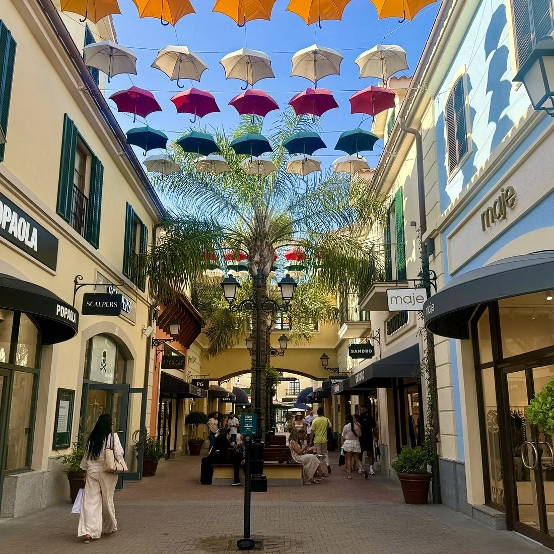 Umbrella-lined shopping street at Plaza Mayor