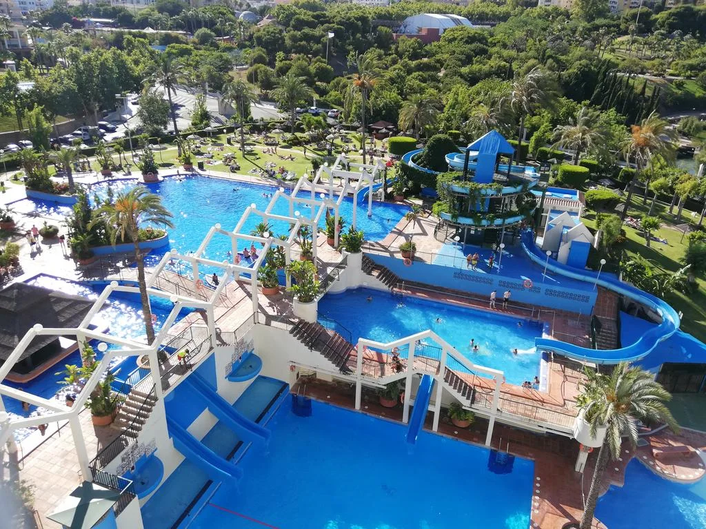 Elevated view across the Benal Beach pools, terraces and blue water slides