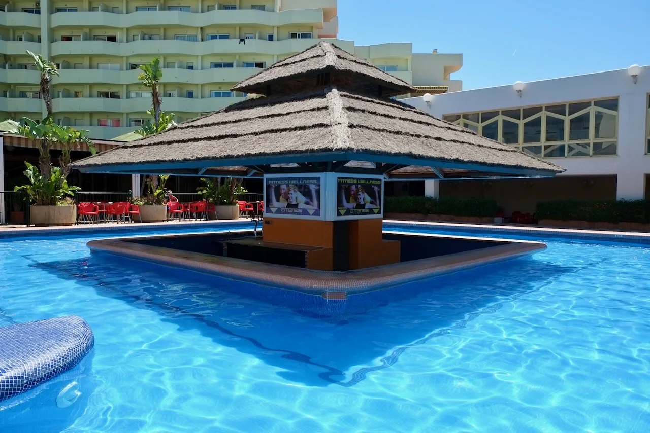 Swim-up pool bar surrounded by clear blue water at Benal Beach