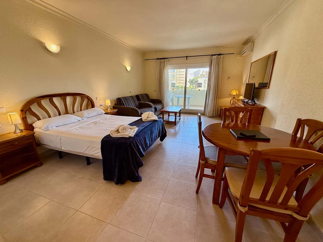 Bright open-plan Kingfisher Studio Suite with a double bed, kitchenette and lounge area at Benal Beach